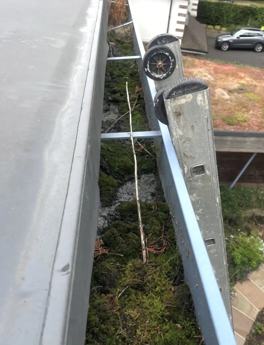 Worker clearing downpipe junction box